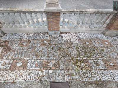Un pavimento �a mosaico� di pietruzze bianche e rosse con la scritta �Villa Rachele�...